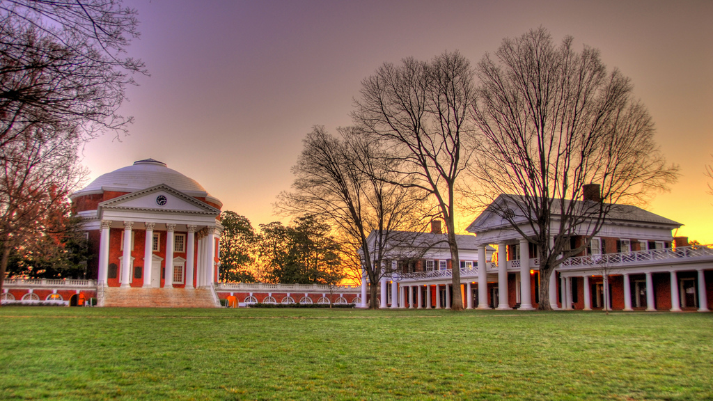 A domed building with columns and a grassy lawn. 