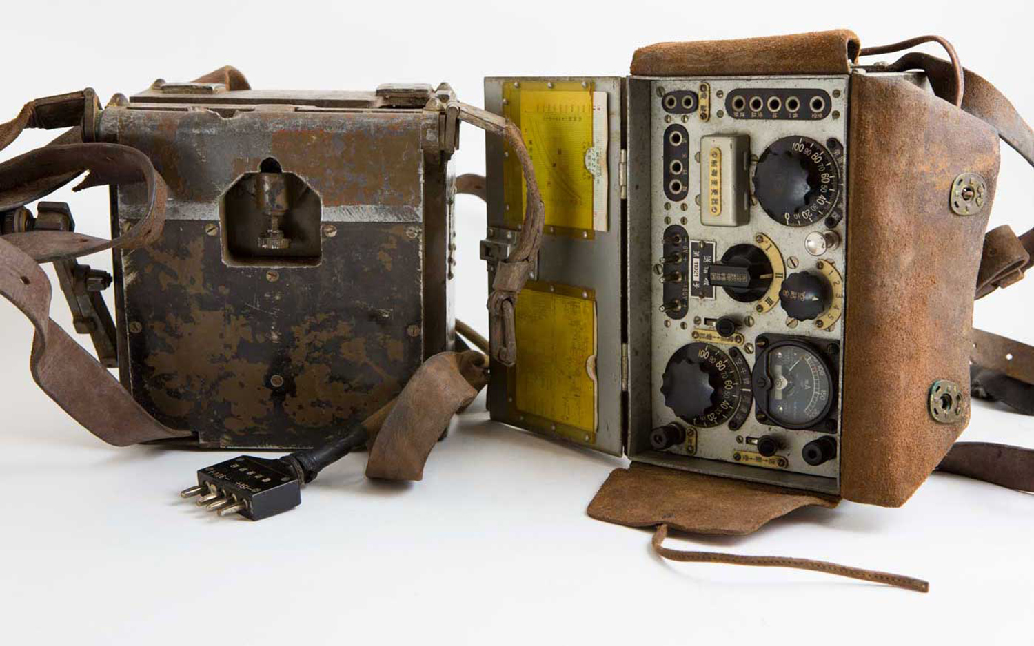 An old, rusted radio, in two parts, partially enclosed in a leather case.