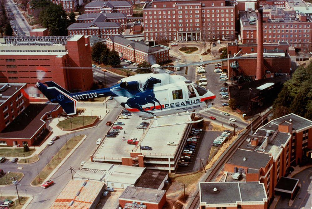 An overhead view of the Pegasus helicopter in flight over the central UVA Hospital campus