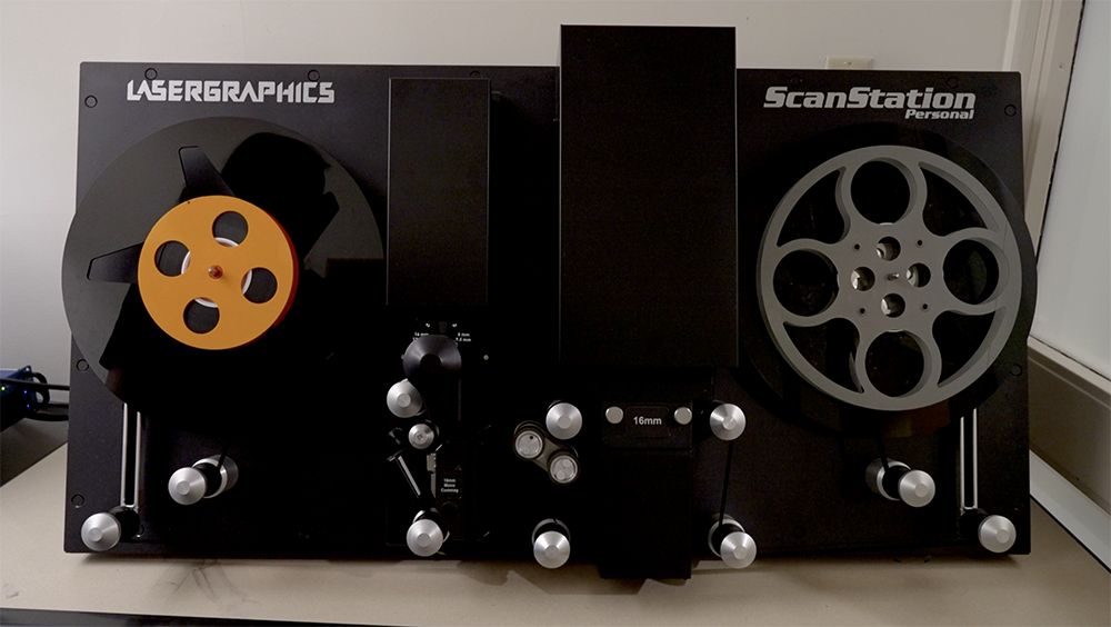 A piece of equipment with two wheels and a track for a film strip.