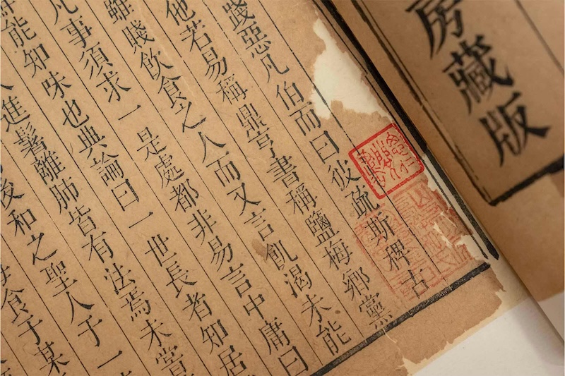 Ancient book pages with traditional Chinese text and a red stamp.