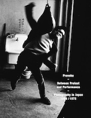 Black and white image of a person energetically throwing a chair, promoting 'Provoke: Between Protest and Performance - Photography in Japan 1960-1975' exhibition.