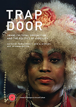 The cover of "Trap Door" shows an African American person staring intently at the camera. They wear bold makeup, a blonde flowered wig, and costume jewelry.